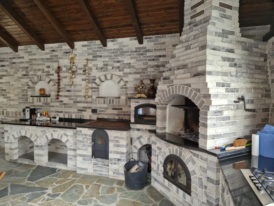 Bucătărie de vară din piatră decorativă, cu cuptor, grătar și blat negru